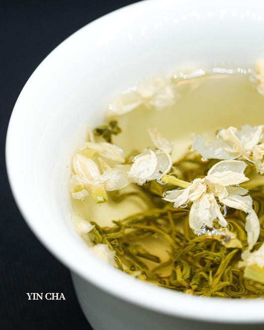 Brewed Jasmine Ballet tea with jasmine flowers in a white teacup