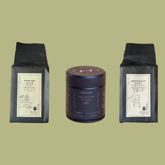 The green polyphenol kit with steam jade tea, jasmine ballet tea, and the veda vana dark blend container arranged on a green background.