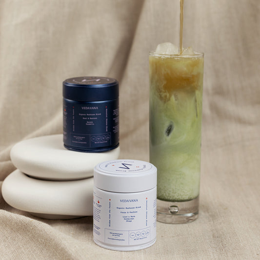 Vedavana Focus and Restore mushroom blends with iced layered tea drink on fabric background