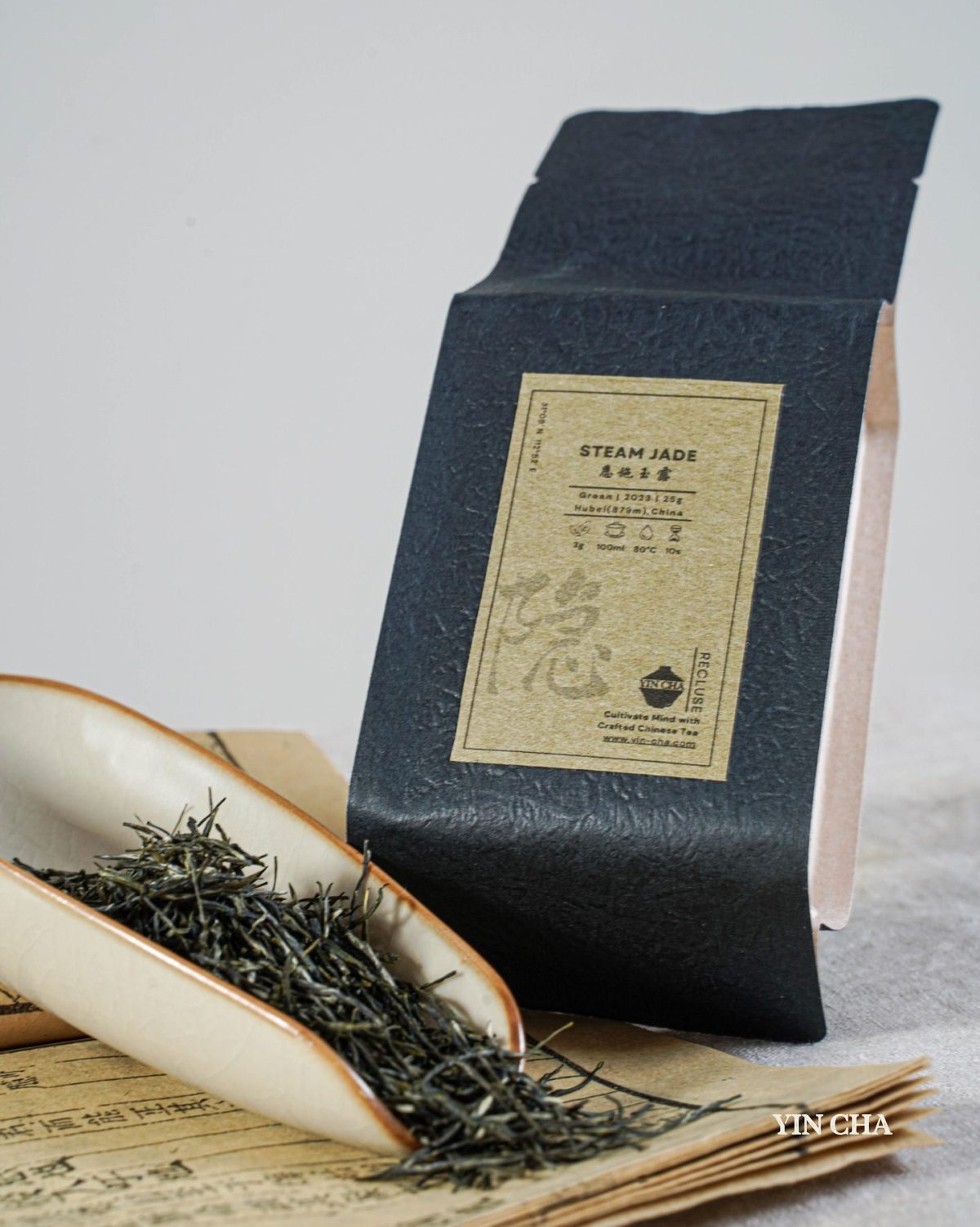 Steam Jade green tea packaging with loose leaves on traditional Chinese paper