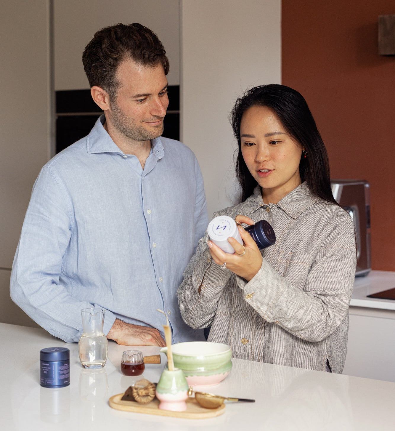 Lex and Addy, co-founders of Veda Vana, in their kitchen examining one of their functional mushroom products.