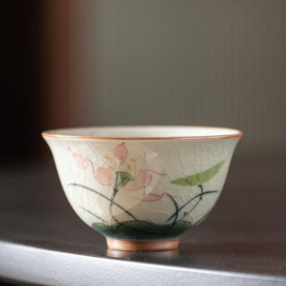 Close-up of porcelain Gong Fu teacup with lotus flower artwork, crafted in Dehua.
