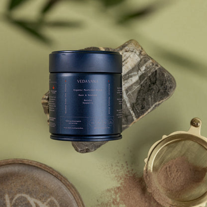 Vedavana Rest & Restore organic reishi blend with loose powder, sieve, and stones on green backdrop